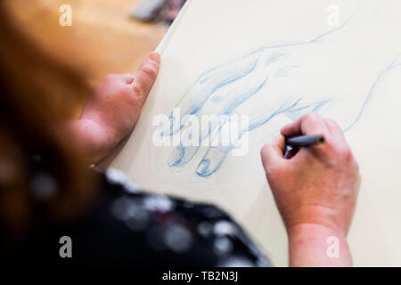 Hohen winkel Nahaufnahme von Künstler Zeichnen der menschlichen Hand. Stockfoto