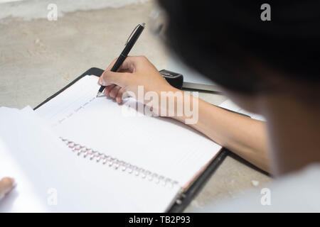 Nahaufnahme Rückansicht Mann tun, zu Hause zu arbeiten und studieren und Hausaufgaben Stockfoto