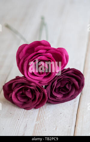 Hohen Winkel in der Nähe von drei rosa und lila Papier Rosen. Stockfoto