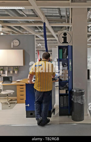 Ein Mitarbeiter an einem Schreibtisch arbeiten am Telefon bei Ikea in Coventry, Großbritannien, am 29. Mai 2019. Stockfoto