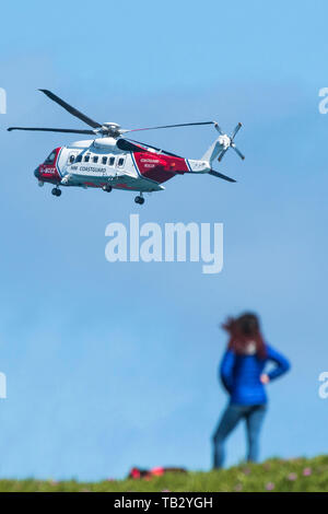 Eine Sikorsky S-92 ein HM Küstenwache SAR-Hubschrauber G-MCCZ von Bristol Hubschrauber fliegen Overhead in England, Großbritannien betrieben. Stockfoto