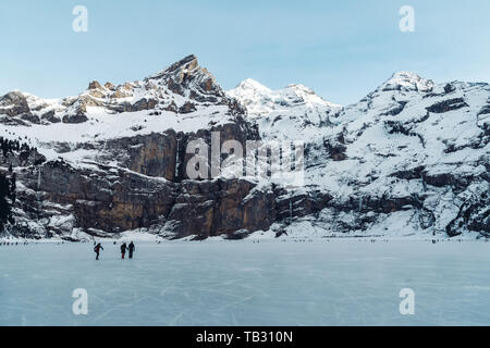 Schlittschuhlaufen auf gefrorenen Oeschinensee See im Berner Oberland Stockfoto