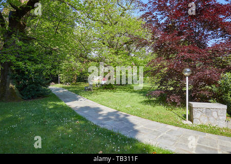 Garten mit Stein Fliesen- Pfad und Straßenlaterne in einem sonnigen Sommertag, Italien Stockfoto