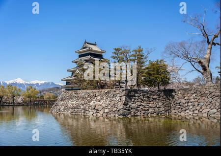 Schloß Matsumoto spiegelt sich in einen stillen See und dem klaren, blauen Himmel Hintergrund Stockfoto