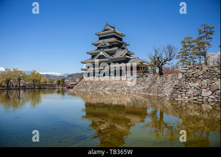 Schloß Matsumoto spiegelt sich in einen stillen See und dem klaren, blauen Himmel Hintergrund Stockfoto