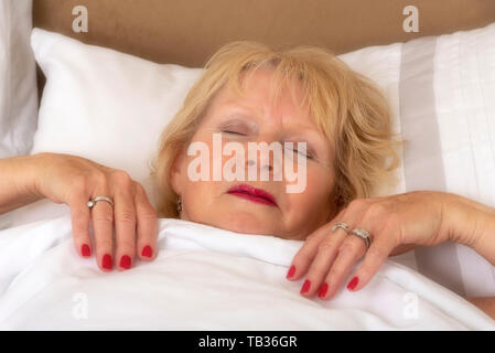 Portsmouth, England, Großbritannien 2019. Eine elederly Frau im Bett schlafend auf einem Kissen Stockfoto