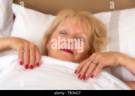 Portsmouth, England, Großbritannien 2019. Eine elederly Frau im Bett schlafend auf einem Kissen Stockfoto