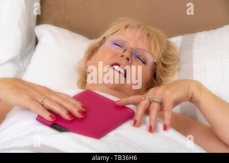 Portsmouth, England, Großbritannien 2019. Eine elederly Frau im Bett mit einem ipad Stockfoto