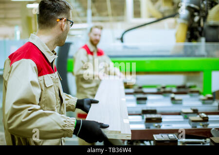 Zwei schöne und junge Männer in der Möbelfabrik arbeiten Stockfoto