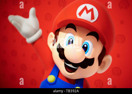 Nahaufnahme auf Super Mario - Charakter von Nintendo Plattform video Spiel auf rotem Hintergrund von der Website Bildschirm fotografiert. Stockfoto