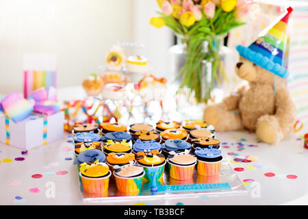 Cupcakes für Kinder Geburtstag feiern. Dschungel Tiere Thema Kinder Party. Zimmer für Junge oder Mädchen Junge Geburtstag eingerichtet. Tabelle Einstellung mit Geschenken, Stockfoto