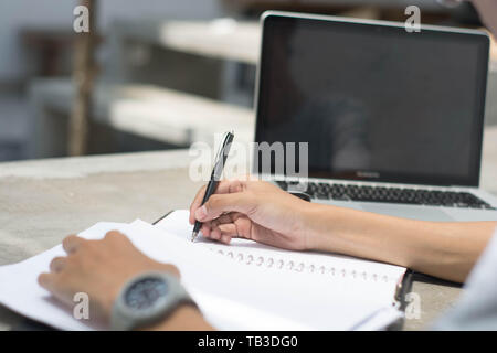Nahaufnahme Rückansicht Mann tun, zu Hause zu arbeiten und studieren und Hausaufgaben Stockfoto