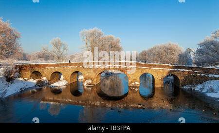 Der Schnee bedeckte 15. Jahrhundert Pershore Alte Brücke über den Fluss Avon, Worcestershire, England Stockfoto