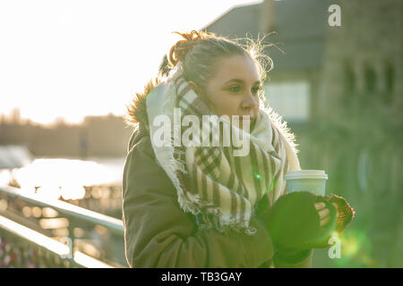 Junge Frau hält eine Tasse, ihre Hände zu warm Stockfoto