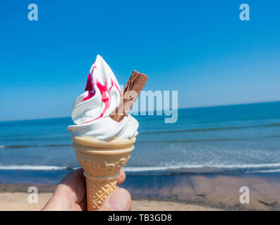 99 Eis mit Himbeeren gegen blues Himmel und Meer. Großbritannien Stockfoto