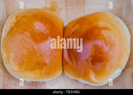 2 Stück von gebackenem Schweinefleisch bun auf einer hölzernen Fach. Stockfoto