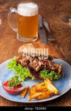 Gezogen von Schweinefleisch in einem Brötchen mit Bier Stockfoto