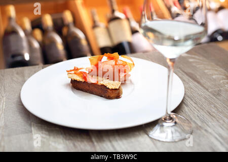 Eine exquisite und elegante Dessert serviert mit einem Glas Weißwein Stockfoto