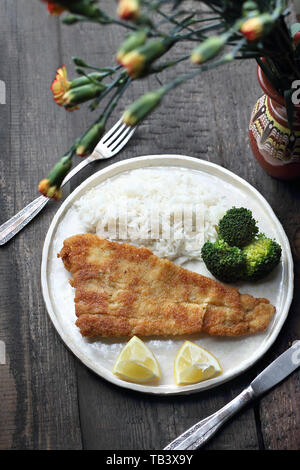 Fisch paniert in Öl gebacken mit Reis und Broccoli. Stockfoto