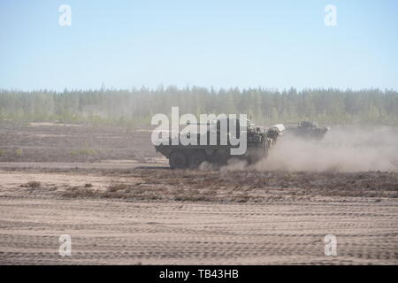 Us-Armee Soldaten aus der Truppe ächten, 4. Staffel, 2d-Cavalry Regiment fahren ihre Stryker Dragoon Fahrzeuge wieder in der Vorbereitung für die Preisverleihung nach dem Finnischen Bataillons Battle Group live fire Übung in der Pojankangas Training Area in der Nähe von Kankaanpaa, Finnland, 17. Mai 2019. Die Zeremonie anerkannt hervorragenden Service Mitglieder der US-Army, US Marine Corps, die finnische Armee, der britischen Armee und der Estnischen Streitkräfte. (U.S. Armee Foto von Sgt. LaShic Patterson) Stockfoto