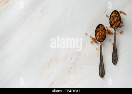 Brauner Zucker in Metall Löffel auf helle, Marmor Hintergrund mit kopieren. Dessert Zutat, Zucker süchtig Stockfoto