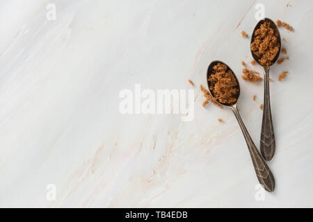 Brauner Zucker in Metall Löffel auf helle, Marmor Hintergrund mit kopieren. Dessert Zutat, Zucker süchtig Stockfoto