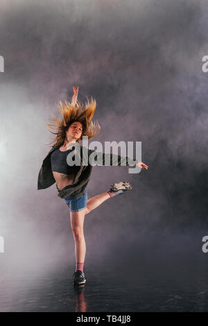 Tänzerin zeigt ihre Eleganz, indem sie ihr Bein hoch über den Kopf. Stockfoto