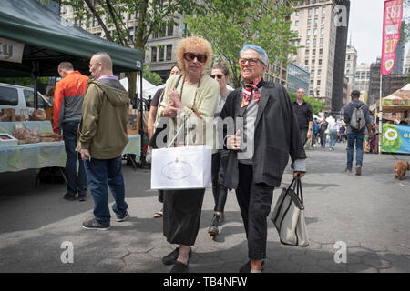 Zwei youthfull Suche Mittlere Alter Frauen Spaziergang durch die Union Square Green Market plaudern und mit Einkaufstüten. In New York City. Stockfoto