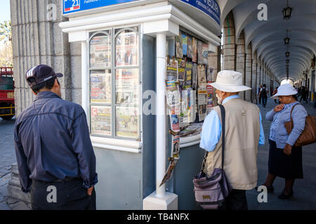 Die Menschen lesen die Zeitungen und Zeitschriften in einer Presse auf der Plaza de Armas oder Hauptplatz von Arequipa, Peru Abschaltdruck Stockfoto