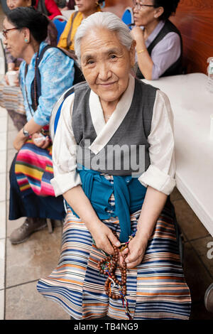 Stellen Portrait eines älteren asiatischen Frau an einem himalayan Musik Konzert in der Sherpa buddhistischen Tempel in Queens, New York City. Stockfoto