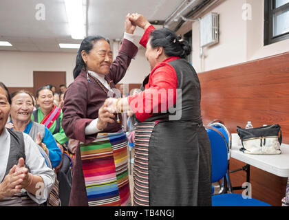 Asiatische Frauen, aus Nepal und Tibet, Tanz in den Gängen, bei einem Konzert von Himalayan Musik an der Sherpa buddhistischen Tempel in Queens, New York City. Stockfoto