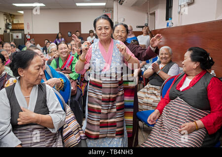 Asiatische Frauen, aus Nepal und Tibet, Tanz in den Gängen, bei einem Konzert von Himalayan Musik an der Sherpa buddhistischen Tempel in Queens, New York City. Stockfoto