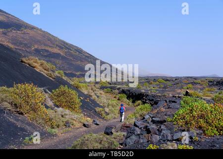 Frau geht auf Wanderweg durch Lavafeld, Naturpark Los Volcanes, in der Nähe von Moya, Lanzarote, Kanarische Inseln, Spanien Stockfoto