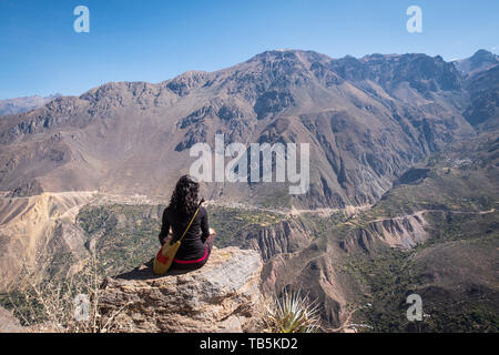 Wanderer eine Pause und genießen Sie einen traumhaften Blick auf einen Aussichtspunkt an der Colca Canyon mit Malata und Cosñirgua Dörfer im Hintergrund, Peru Stockfoto