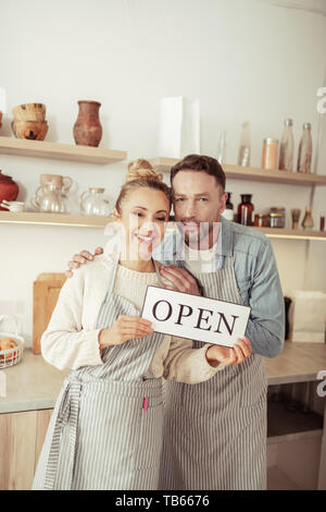 Neue beginnt. Zwei glücklich lächelnde Besitzer eines kleinen gemütlichen Café gerade eröffnet dieser plase stehen in der Küche. Stockfoto