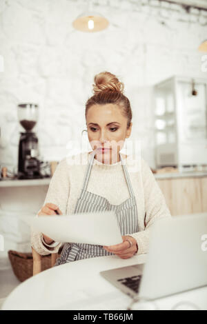 Arbeit planen. Smart Business Frau am Tisch sitzen vor einem kaffeemühle und arbeiten an der Entwicklung von ihr Cafe. Stockfoto