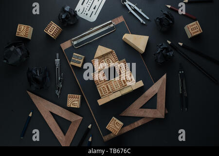 Hausbau, Planung, Kontrolle und Reparatur Konzept. Holzblock home auf einem Klemmbrett mit technischer Ausrüstung, Zirkel, Lineal und Bleistift. Arbeit Stockfoto