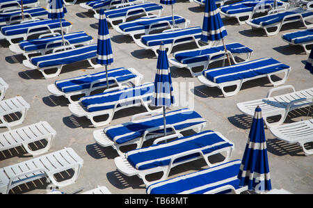 Grafik Reihen von blauen und weißen Handtüchern und Sonnenschirmen und Liegestühlen am Strand in Nizza, Südfrankreich, Côte d'Azur. Stockfoto