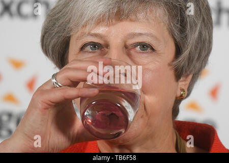 Premierminister Theresa May Getränke ein Glas Wasser gibt, wie Sie eine Rede im Zentrum von London bietet als Reaktion auf die Post-18 Ausbildung und Förderung. Stockfoto