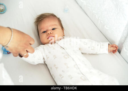 Ein neugeborenes Baby liegt in der Baumschule auf dem Bett. Stockfoto