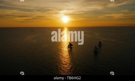 Sonnenuntergang über dem Meer Fläche mit Segelbooten, Luftaufnahme Boracay, Philippinen. Spiegelt sich die Sonne auf einer Wasseroberfläche. Sonnenuntergang über dem Meer. Marine, Sommer und Reisen Urlaub Begriff Stockfoto