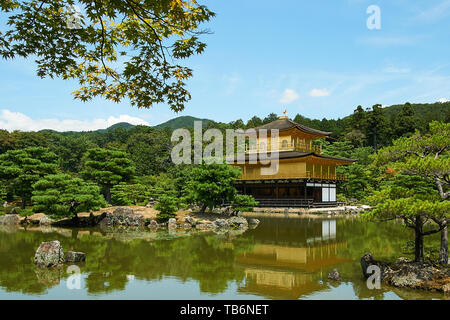 Kinkakuji (goldener Pavillon) reflektiert auf dem Wasser, von Bäumen und japanische Landschaft umgeben, an einem klaren, sonnigen Sommertag in Kyoto, Japan. Stockfoto