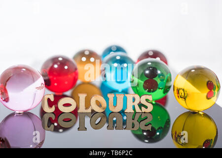 Abstrakte Komposition mit transparenten Kugeln aus Glas und Holz Buchstaben. Stockfoto