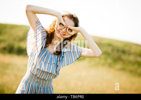 Young Pilot Mädchen vorgibt, Fliegen mit gefälschten Gläser und vintage Helm, auf einer Wiese Stockfoto