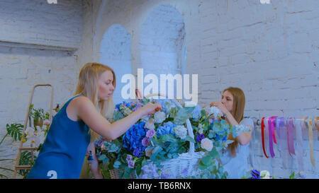 Zwei Frauen, Floristen, großen floralen Korb mit Blumen Flower Shop Stockfoto