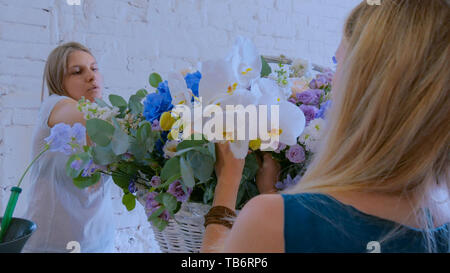 Zwei Frauen, Floristen, großen floralen Korb mit Blumen Flower Shop Stockfoto