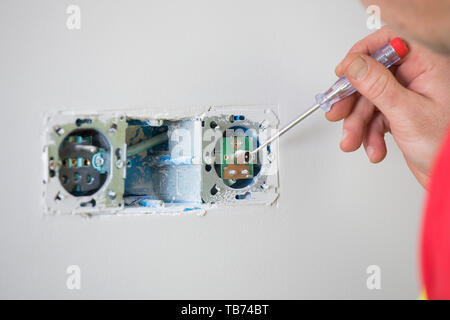 Elektriker auf der Arbeit, zu Hause Renovierung, Elektroinstallation, Hand an einen Elektriker. Stockfoto