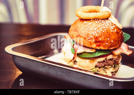 Close up Tall leckere Burger mit Käse auf dem Tablett serviert. Stockfoto
