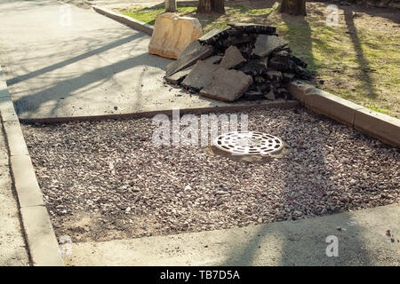 Asphalt und Straße geöffnet. große Grube mit Steinen auf dem Asphalt Autobahn. Straßenbau und Instandsetzung Stockfoto