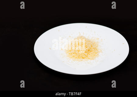 Zerfetztes geriebenen Käse auf schwarzen Hintergrund, Nahaufnahme Stockfoto